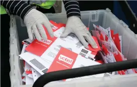  ?? Associated Press ?? ■ This March 10, 2020, file photo shows a King County Election worker wearing gloves while collecting ballots from a drop box in the Washington State primary in Seattle. Washington is a vote-by-mail state.