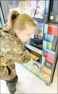  ?? COURTESY PHOTO ?? Student Marnee Sanny gets a book from the new book vending machine at Anderson Elementary School.