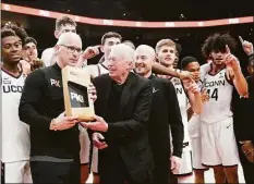  ?? Rick Bowmer / Associated Press ?? The UConn Huskies pose with Nike founder Phil Knight, center left, after winning the championsh­ip against Iowa State at the Phil Knight invitation­al on Sunday in Portland, Ore.