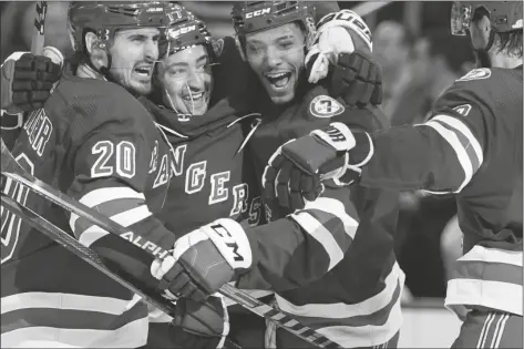  ?? FRANK FRANKLIN II/AP ?? NEW YORK RANGERS’ CHRIS KREIDER (20) celebrates with teammates K’Andre Miller (79) and Jacob Trouba (8) after scoring a goal during the second period of Game 2 of a first-round playoff series against the Pittsburgh Penguins, Thursday in New York.