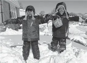  ?? TANIKA DAVIS ?? The writer’s two sons take full advantage of a snow day in 2016, while mom worked from home inside. But not during this year’s storm.