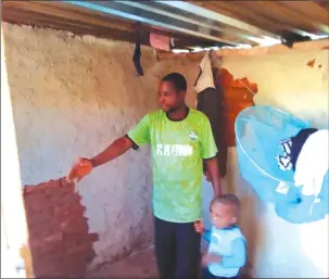  ??  ?? MR WARURE points to where water was oozing from inside his bedroom hut last week