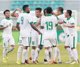  ??  ?? Indonesia players celebrate a goal against Mongolia.