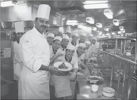  ??  ?? Executive chef aboard the Statendam, Bitt Kuruvillas, and his assistants proudly display their kitchen — the busiest place on the ship.