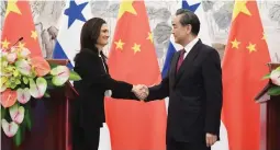  ??  ?? Panama’s Vice President and Foreign Minister Isabel de Saint Malo (L) shake hands with Chinese Foreign Minister Wang Yi during a joint press briefing after they signed a joint communique agreeing to establish diplomatic relations in Beijing, China on...