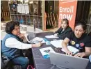  ??  ?? Leticia Galvez helps enroll Maria Knoll in an Affordable Care Act insurance plan at the James R. Thompson Center on Wednesday.