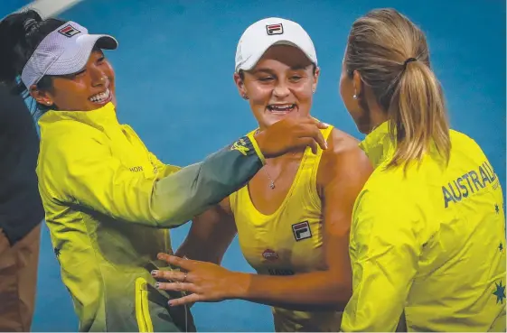  ?? Picture: AFP ?? Ashleigh Barty (centre) is embraced by Priscilla Hon (left) and Australian captain Alicia Molik after the win at Pat Rafter Arena.