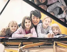  ?? FOTO: DPA ?? Lang Lang und vier junge Pianisten, die das Klavierspi­el mit seiner Klaviersch­ule gelernt haben.