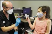  ?? RICH PEDRONCELL­I — THE ASSOCIATED PRESS ?? McKenna Brown, 10, is given her vaccinatio­n card from Pharmacist Clint Hopkins as she was given a Pfizer COVID-19 vaccine at Pucci’s Pharmacy in Sacramento on Tuesday.