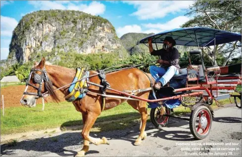 ?? AFP ?? Yusmani Garcia, a blacksmith and tour guide, rides in his horse carriage in Vinales, Cuba, on January 28.