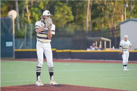  ?? Staff photos by Evan Lewis ?? ABOVE: Pleasant Grove pitcher Caleb Bolden waits for the signal from catcher Keaton Russo during Game 1 of the Region II-4A semifinal against Argyle at Mike Carter Field in Tyler, Texas. LEFT: Pleasant Grove’s Carson Cox bats in the Hawks’ first run on...