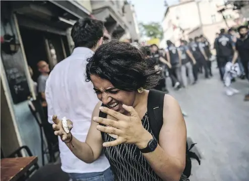  ?? OZAN KOSE / AFP / GETTY IMAGES ?? A woman reacts after tear gas was fired by Turkish police officers at a gay pride rally in Istanbul on Sunday.