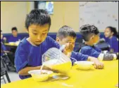  ?? Ashlee Rezin Garcia The Associated Press ?? A student pours milk on his breakfast cereal Friday at a Chicago Public Schools student contingenc­y site.