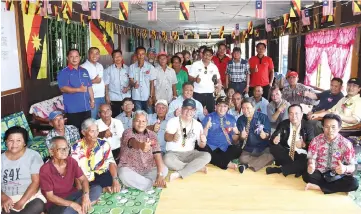  ??  ?? Ahmad Johnie, Safiee and Siaw (on floor, front row – fifth, fourth and third right, respective­ly) join the longhouse villagers in a group photo.