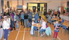  ??  ?? Visitors at the Whiting Bay Primary Christmas fair listen to the bake-off winner announceme­nt.