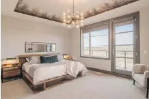  ??  ?? The master bedroom features a tray ceiling design with a smoky finish.