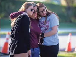  ?? ALEX DRIEHAUS/USA TODAY NETWORK ?? Cheryl Rothenberg and her daughters, Emma, 20, left, and Sophia, 17, pay their respects in Parkland, Fla.
