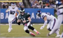  ?? JULIO CORTEZ — THE ASSOCIATED PRESS ?? Philadelph­ia Eagles quarterbac­k Carson Wentz (11) slides as New York Giants’ Evan Brown (67) closes in during the first half of an NFL game Thursday, Oct. 11, in East Rutherford, N.J.