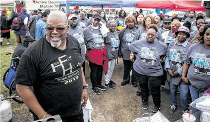  ?? Photos by Annie Mulligan / Contributo­r ?? Pastor Darrel W. Boson, above left, of New Hope Missionary Baptist Church laughs with volunteers during the fifth annual Hope for Houston Showers & Blessings for the Homeless Community on Saturday in Houston. Ten-week-old Leah James, top, smiles with her mom, Jessica Edwards.