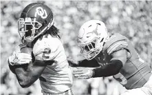  ?? Jeffrey McWhorter / Associated Press ?? Oklahoma WR CeeDee Lamb, who had 10 catches for 171 yards, beats Texas’ Brandon Jones for one of his three scores.