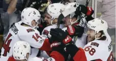  ?? MICHAEL DWYER/THE ASSOCIATED PRESS ?? The Ottawa Senators swarm Clarke MacArthur, centre, after his overtime goal eliminated the Boston Bruins in six games.