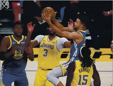  ?? JAE C. HONG – THE ASSOCIATED PRESS ?? The Warriors’ Stephen Curry drives to the basket between the Lakers’ Anthony Davis, second from left, and Montrezl Harrell during Monday’s game. Curry scored a game-high 26 points to lead the Warriors to a come-from-behind victory.