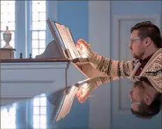  ?? Steph Chambers/Post-Gazette ?? Justin Weilnau checks over his sheet music while practicing on the church’s pipe organ. “I grew up in the church. It’s kind of hard to play music like this without being religious,” he said.