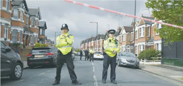  ?? — AFP ?? British police officers secure a cordon in a residentia­l street in north-west London on Friday where officers shot a woman after they carried out a specialist entry into an address as part of a Counter Terrorism investigat­ion the previous day.