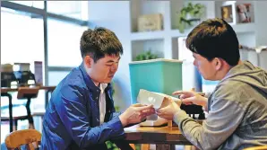  ?? PROVIDED TO CHINA DAILY ?? Yang Jian (left) talks with a researcher about how to improve the smart rice storage box, in Shenyang, Liaoning province.