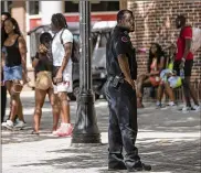  ?? ALYSSA POINTER/ ALYSSA.POINTER@AJC.COM ?? A Clark Atlanta University Police officer keeps an eye out as students socialize near the university’s student center on the main campus in Atlanta on Wednesday.