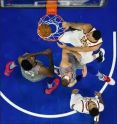  ?? CHRIS SZAGOLA — THE ASSOCIATED PRESS ?? The Cavaliers’ Larry Nance Jr., right, dunks as the 76ers’ Mike Muscala, center, and Joel Embiid, left, look on Friday in Philadelph­ia. The Cavaliers won 121-112.