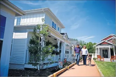  ??  ?? Andrew Sakallaris, 68, left, and his wife, Bonnie, 67, walk along the boardwalk of their Railroad Cottages community in Falls Church, Virginia. [SARAH L. VOISIN PHOTOS / THE WASHINGTON POST]