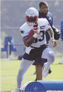  ?? AP PHOTO ?? IN THE RUNNING: Jeremy Hill, who signed with the Patriots after four seasons with the Bengals, goes through a drill yesterday in Foxboro.