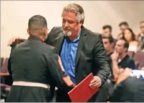  ?? Dan Watson/The Signal (See additional photos on signalscv.com) ?? Jake Solley’s father, Jim, right, is presented a certificat­e from Dean Hurtado, a U.S. Marine master sergeant, during a memorial service for Jake held in the Valencia High School theater on Saturday.