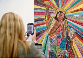  ?? — AFP ?? a woman takes a picture of an artwork titled L.A. Liberty by Pacita abad at the recent Frieze art Fair in London.