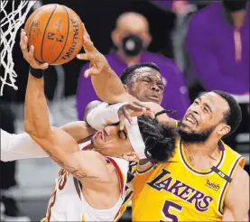  ??  ?? Mark J. Terrill The Associated Press Cavaliers guard Brodric Thomas tries to go to the basket against Lakers guards Dennis Schroder, rear, and Talen Horton-tucker in the second half of Los Angeles’ 100-86 victory Friday night at Staples Center. Schroder scored 17 points.