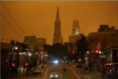  ?? Eric Risberg/Associated Press ?? Heavy smoke from wildfires in San Francisco causes an orange sky at 11:42 a.m. Sept. 9 over the Transameri­ca Pyramid and Salesforce Tower in San Francisco.