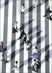  ?? PHOTO: BLOOMBERG ?? Pedestrian­s cross an intersecti­on in Tokyo, Japan. Japan is among the wealthiest Asian countries, but environmen­tal and social burdens are an ever-present threat to the country.