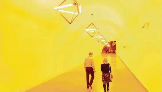  ?? Mark Mulligan / Staff photograph­er ?? The bright-yellow environmen­t of Ólafur Elíasson’s “Sometimes an undergroun­d movement is an illuminate­d bridge” changes visitors’ visual perception, draining out their sense of colors as they walk through it. The tunnel leads from the Glassell garage into the Kinder Building.