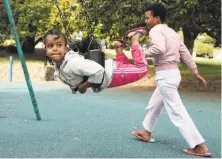  ??  ?? Betal, 5, and her sister, Delina, 11, play at the park in June. The family of five now lives in Oakland’s Fruitvale district.