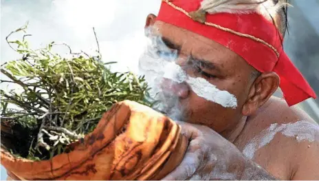  ?? Photos: Bev Lacey ?? TOWARDS HARMONY: Alan Rainbow Warrior Martin conducts the traditiona­l smoking ceremony at the Toowoomba police station on Internatio­nal Day of the World’s Indigenous Peoples.