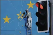  ?? AP/GARETH FULLER ?? A view of a Banksy Brexit mural in Dover, England, shows a man chipping away at the EU flag Tuesday.