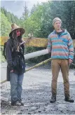  ?? TIMES COLONIST ?? Angela Davidson, left, is padlocked to a logging road gate and chained to another person shortly before being arrested on May 18, 2021.