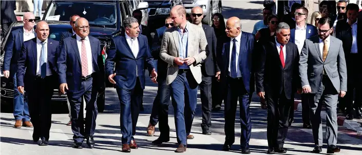  ??  ?? Tight security: Prince William speaks with the mayor of Ramallah at an outdoor festival of Palestinia­n culture. He is the first royal to visit the occupied territorie­s