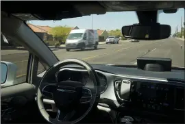  ?? ROSS D. FRANKLIN — THE ASSOCIATED PRESS ?? A Waymo minivan moves along a city street as an empty driver’s seat and a moving steering wheel drive passengers during an autonomous vehicle ride in Chandler, Ariz. The U.S. government’s highway safety agency has ordered automakers to report any crashes involving fully autonomous vehicles or partially automated driver assist systems. The move by the National Highway Traffic Safety Administra­tion indicates the agency is taking a tougher stance on automated vehicle safety than in the past.