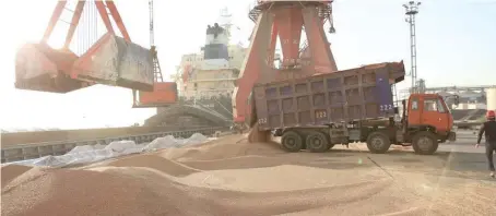  ??  ?? Workers transport imported soybeans at a port in Nantong, Jiangsu province. — Reuters