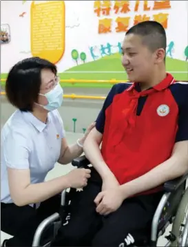  ?? PROVIDED TO CHINA DAILY ?? Ma Hailun (left) talks to a boy at a rehabilita­tion center for children with disabiliti­es on June 1, which marks Internatio­nal Children’s Day, in 2022.