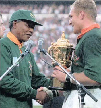  ?? PHOTO: AP ?? South African rugby captain Francios Pienaar, right, receives the Rugby World Cup trophy from President Nelson Mandela who sported a South African rugby shirt the day South Africa defeated New Zealand, in this June 1995 photo. Madiba’s messages were...