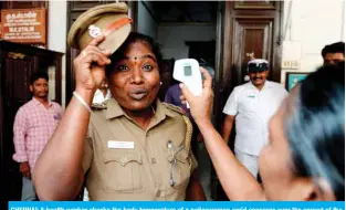  ??  ?? CHENNAI: A health worker checks the body temperatur­e of a policewoma­n amid concerns over the spread of the COVID-19 novel coronaviru­s yesterday. — AFP