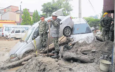  ?? ÉDGAR VARGAS ?? Ciudadanos y autoridade­s se sumaron a las labores de limpieza de las viviendas y los automóvile­s. Vendrían otros cuatro días de lluvia.